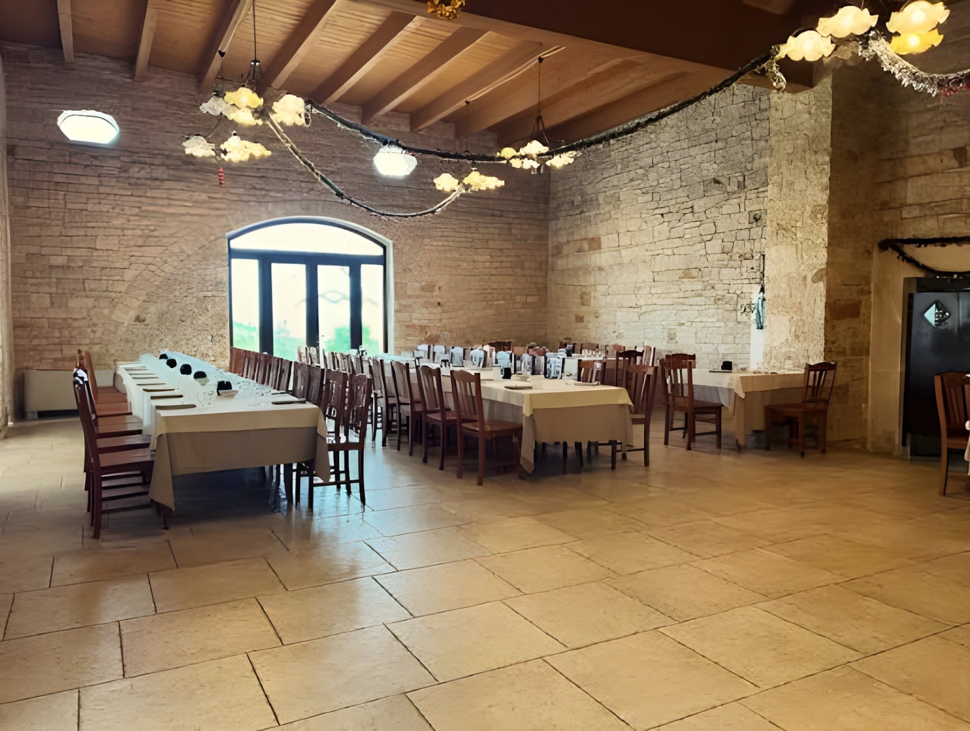 Sala ricevimenti dell'agriturismo a Ruvo di Puglia con volte in pietra e tavoli apparecchiati